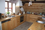 I ve srubové kuchyni můžete hravě kombinovat moderní prvky s přírodní krásou dřeva.